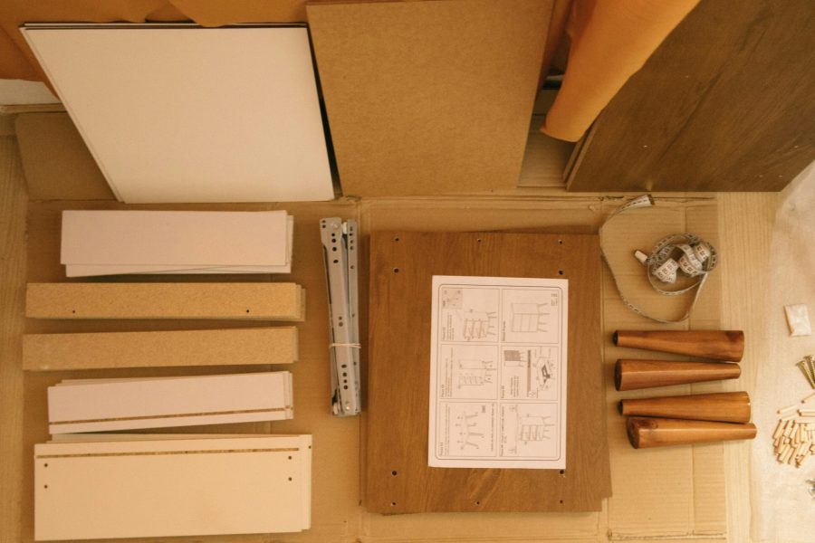 Flat lay of a DIY furniture assembly kit with instructions and tools.